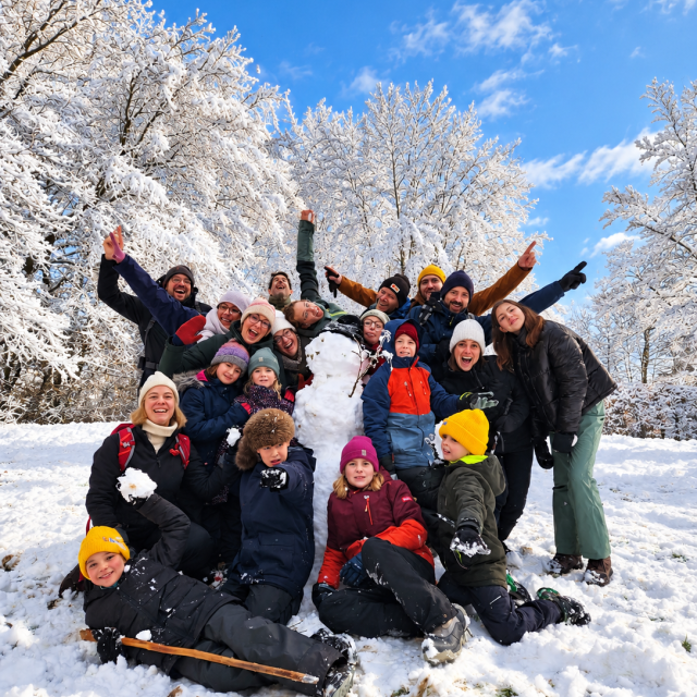 Vrolijke wintergroep rond de sneeuwman